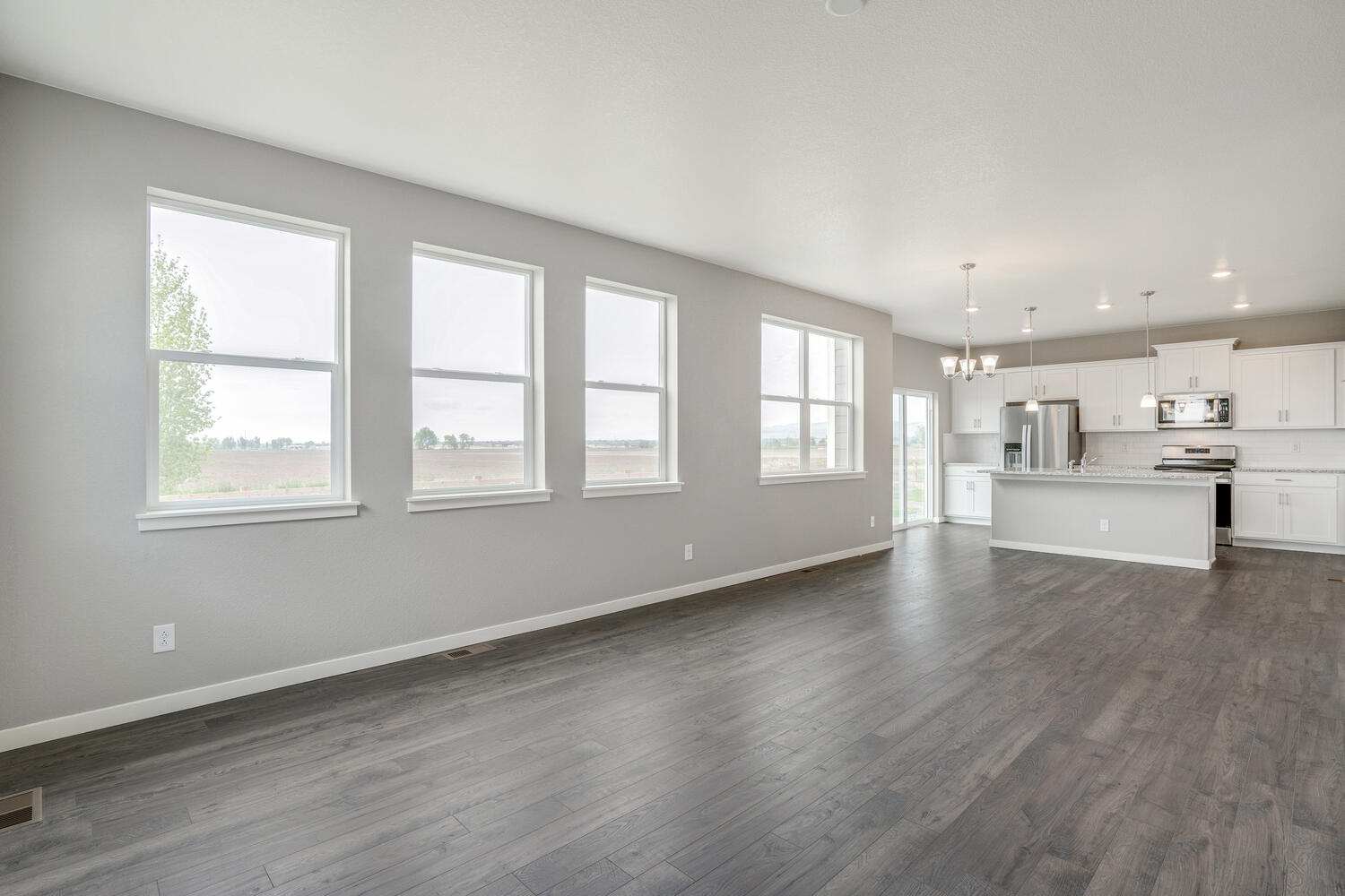 open space living room and kitchen with four windows