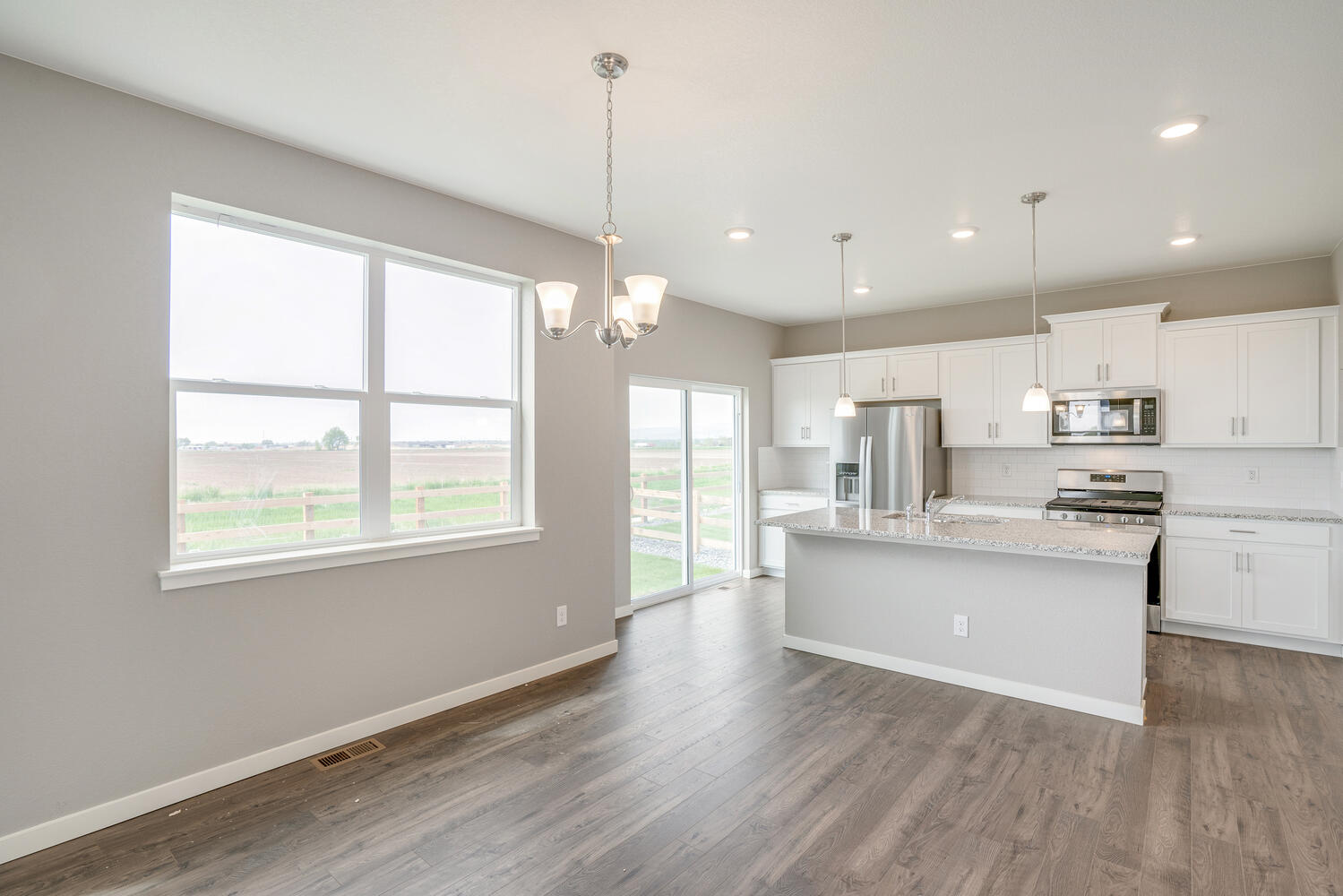 white cabinet kitchen with stainless steel appliances, a window, back door and an island