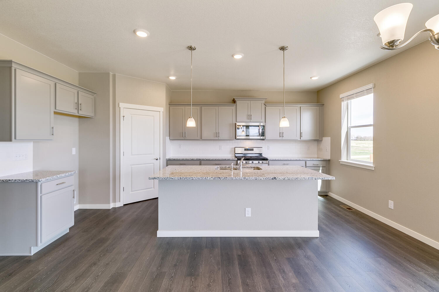 straight view gray cabinet kitchen with stainless steel appliances, and an island
