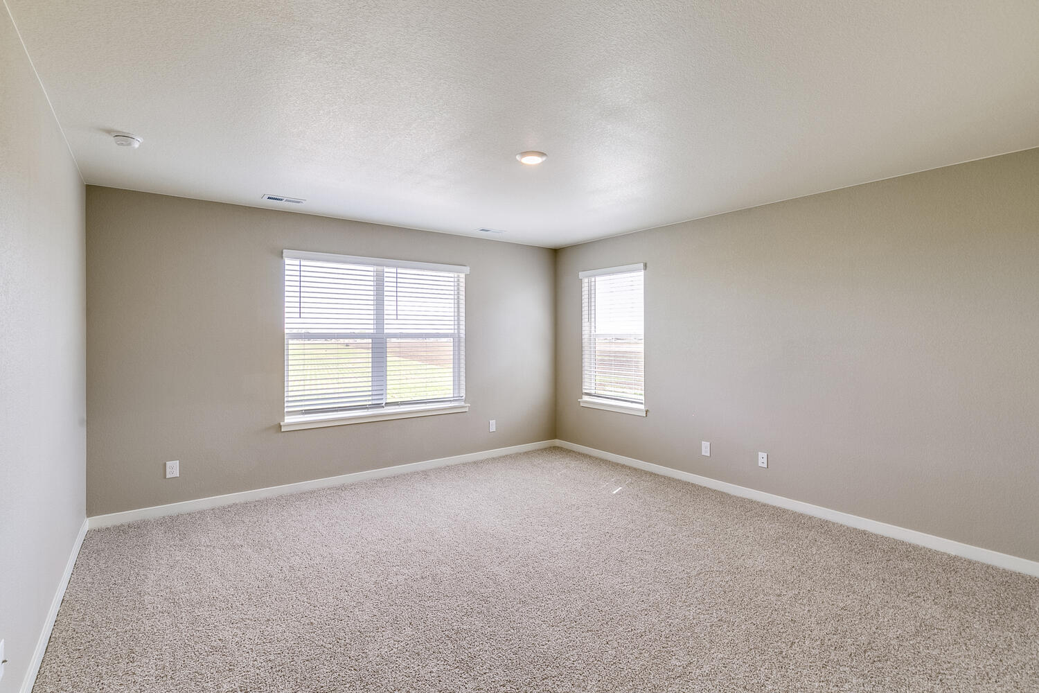 second floor loft with carpet floor and two windows