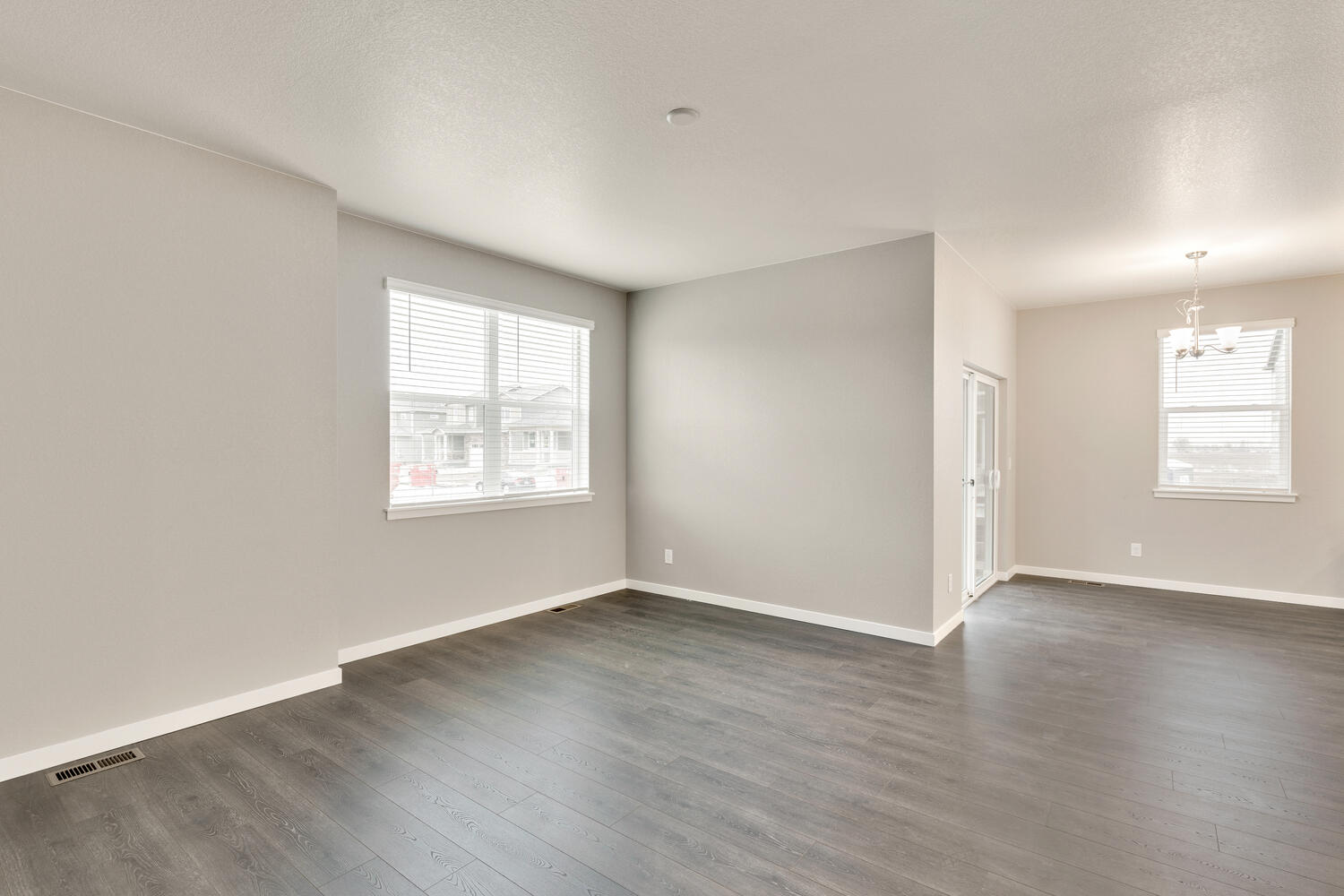 open space living room with hard wood floor and two windows