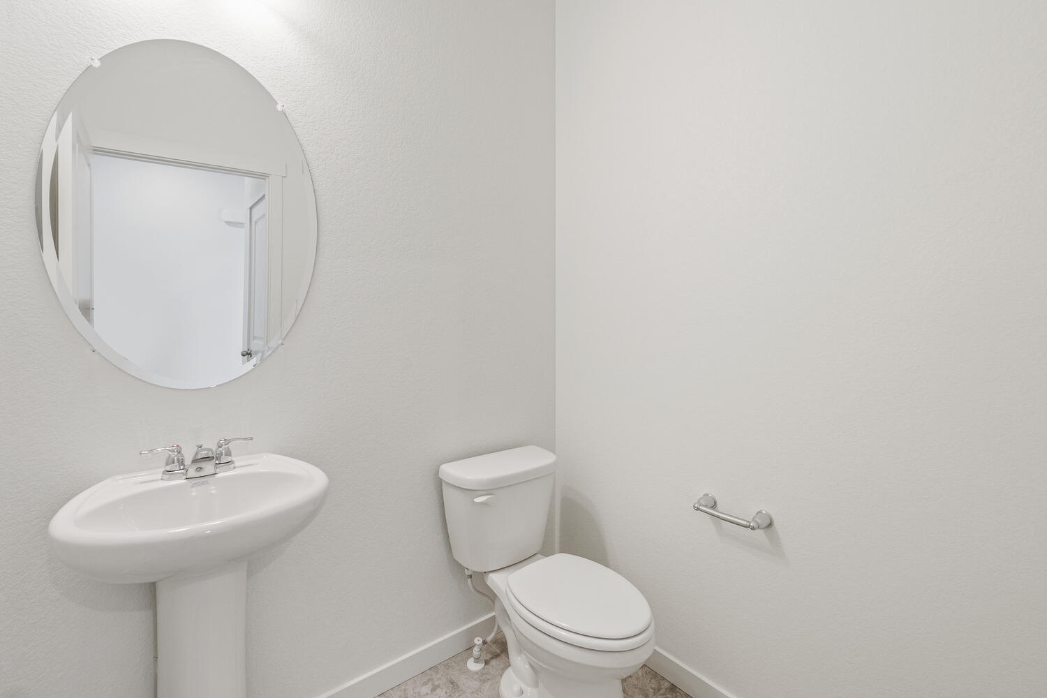 half bath with a round window, sink and toilet