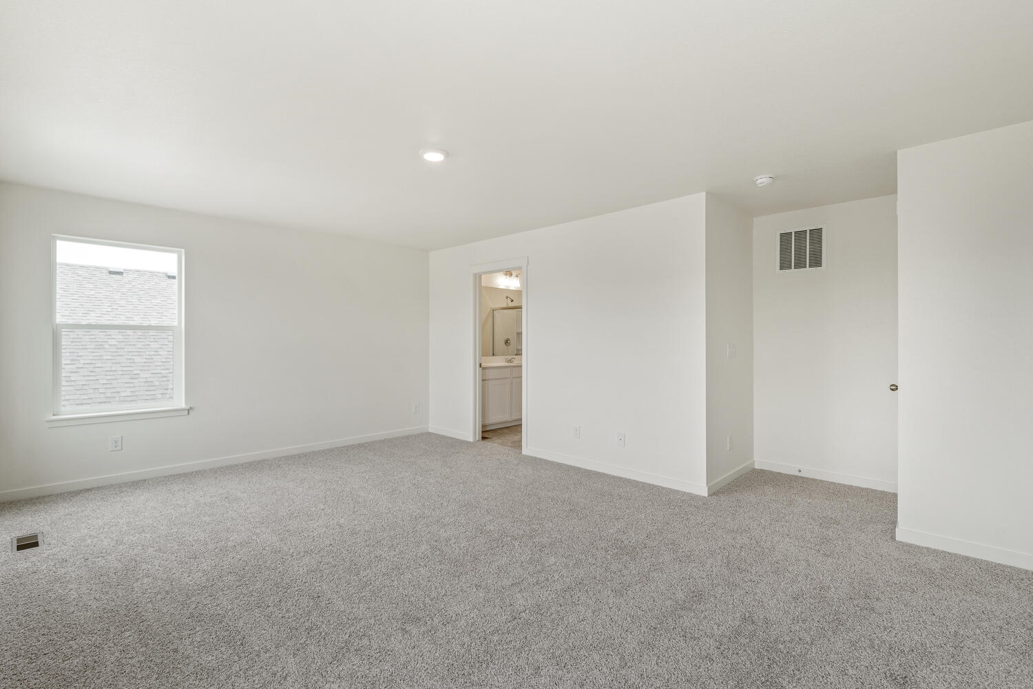 bedroom with a window and door to bathroom
