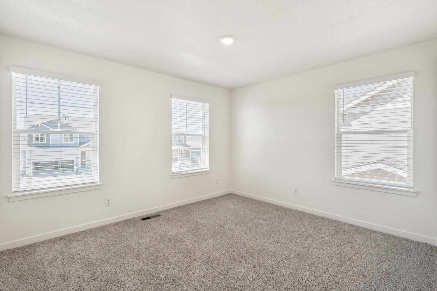 bedroom with three windows and carpet floor