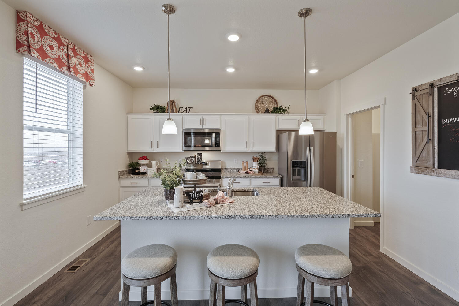 white gray cabinet kitchen with ceiling lights, an island and stainless appliances