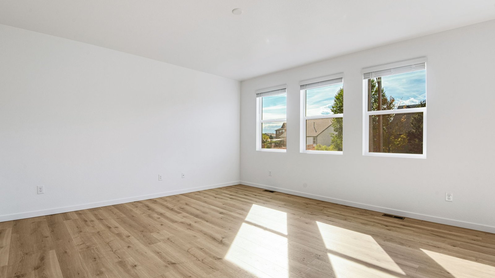Living room space with large windows in new home community Brighton Crossing