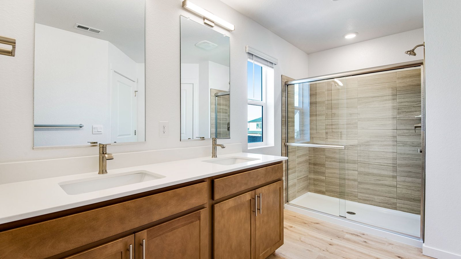 Attached private primary bathroom with dual vanity sinks in new home at Brighton Crossing Community