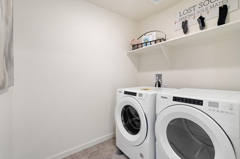 walk-in laundry room with shelving and full washer and dryer