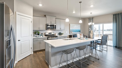 staged gray cabinet kitchen with an island and stainless-steel appliances