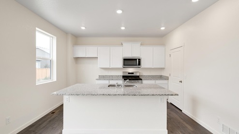 white cabinet kitchen with stainless steel appliance and an island