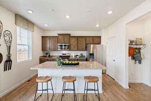 spacious kitchen with kitchen island and three barstools