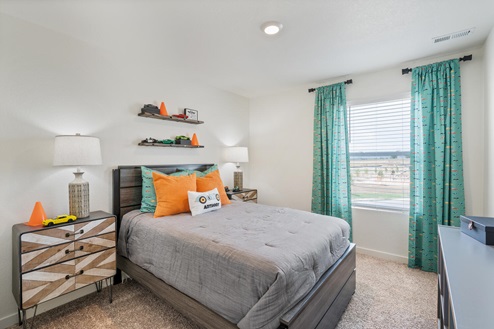 spacious bedroom with full size bed and nightstands and windows bringing in natural light