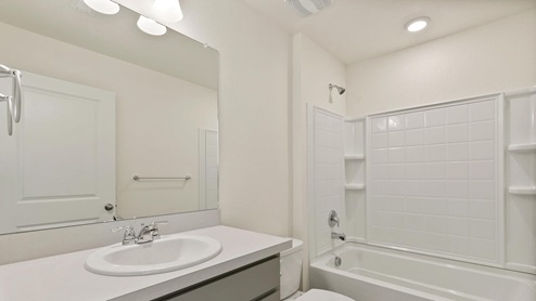 light gray cabinet bathroom with a tub