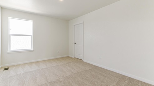 large bedroom with a window and carpet floor