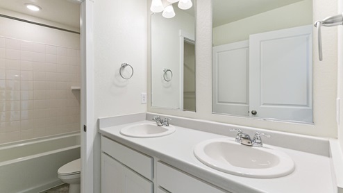 bathroom with white cabinets and separate space for the toilet