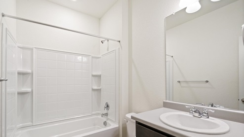 gray cabinet bathroom with a tub