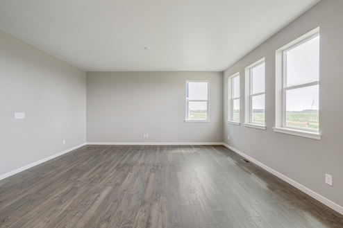 straight view of living room with three windows on the right side and wood floor