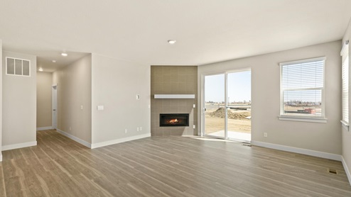 open space concept living room with a fireplace, back door and a window