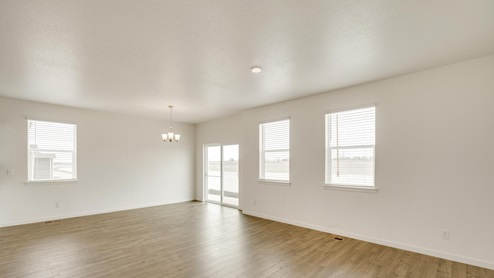 living room with three windows, a back door and wood floor