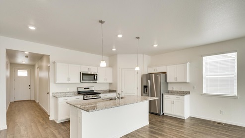 white cabinet kitchen with an island, window, ceiling light and stainless steel appliances
