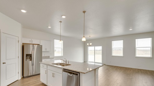 kitchen view of spacious living and dining room with ceiling lights and windows