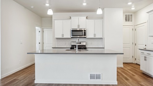 white cabinet kitchen with an island and stainless steel appliances