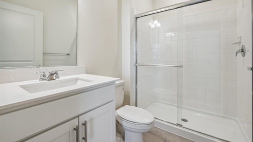 bathroom with a shower and white cabinet