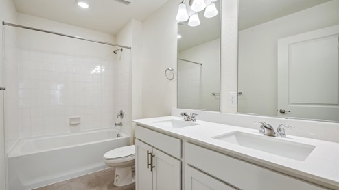 bathroom with a tub and white cabinet