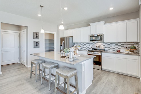 spacious kitchen with white cabinets and kitchen island with barstools