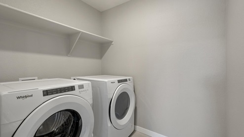 laundry room with a washer and dryer and a shelf