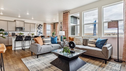 Living room sharing open space with kitchen offering ample natural lighting with three windows