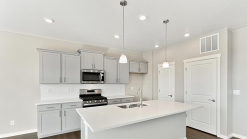 kitchen with pendant light above island and stainless steel appliances