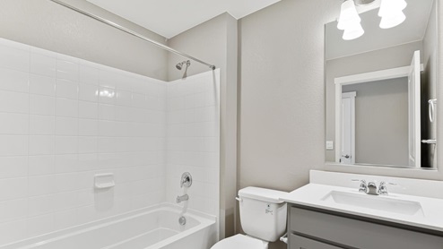 grey cabinet bathroom with tub