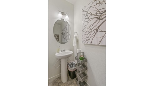 staged half bath with a mirror and sink