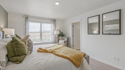 staged main bedroom with a window and carpet flooring