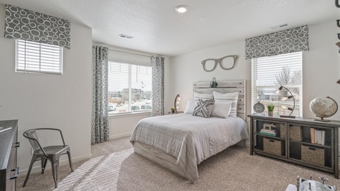 staged bedroom with three windows and carpet flooring
