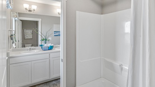 staged white cabinet bathroom with a tub