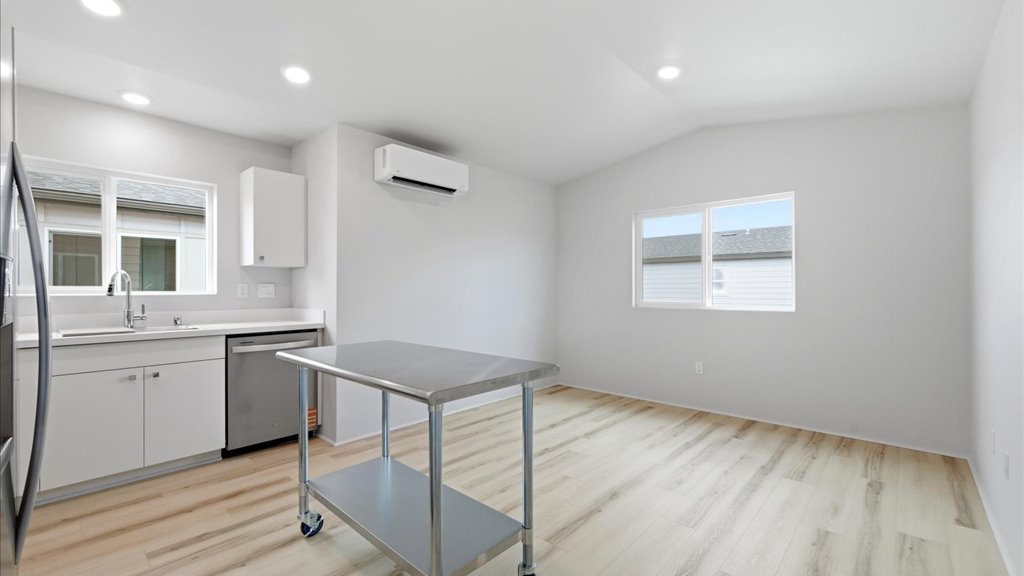 Interior kitchen with stainless steel appliances open to living room