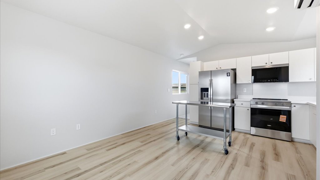 Interior kitchen with stainless steel appliances open to living room