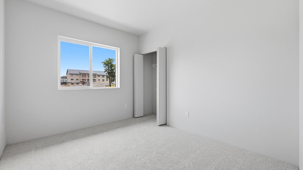 Interior bedroom with sliding closet doors and large window