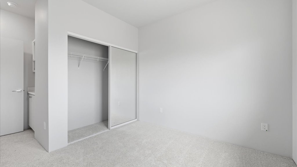 Interior bedroom with sliding closet door and large window