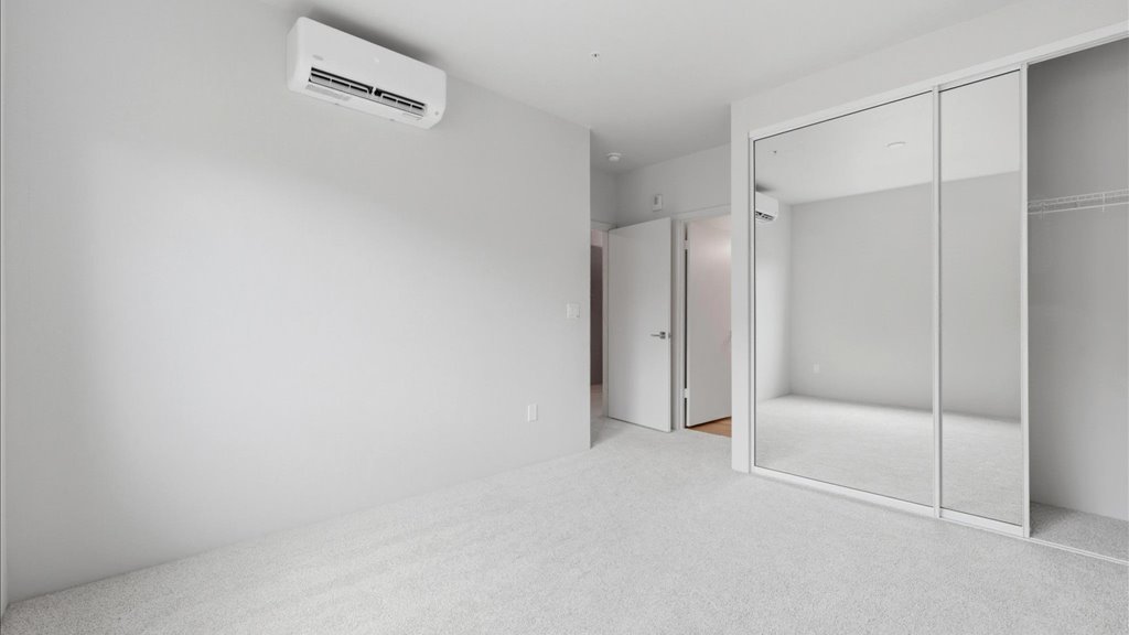 Interior bedroom with sliding closet doors open to bathroom