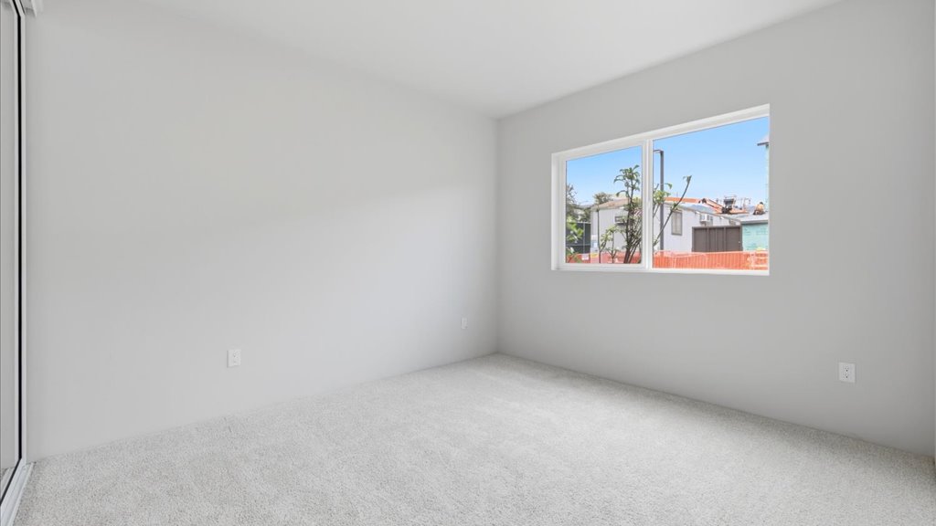 Interior bedroom with sliding closet doors and large window