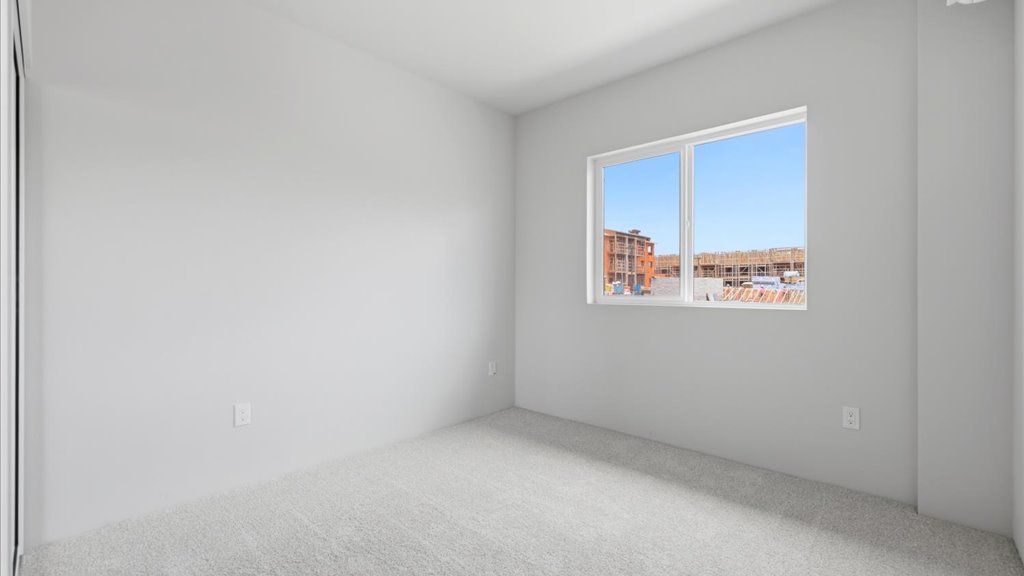 Interior bedroom with sliding closet doors and large window