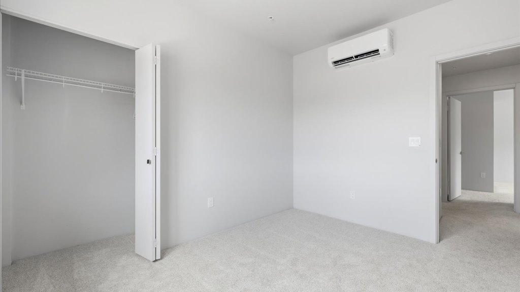 Interior bedroom with sliding closet doors and large window