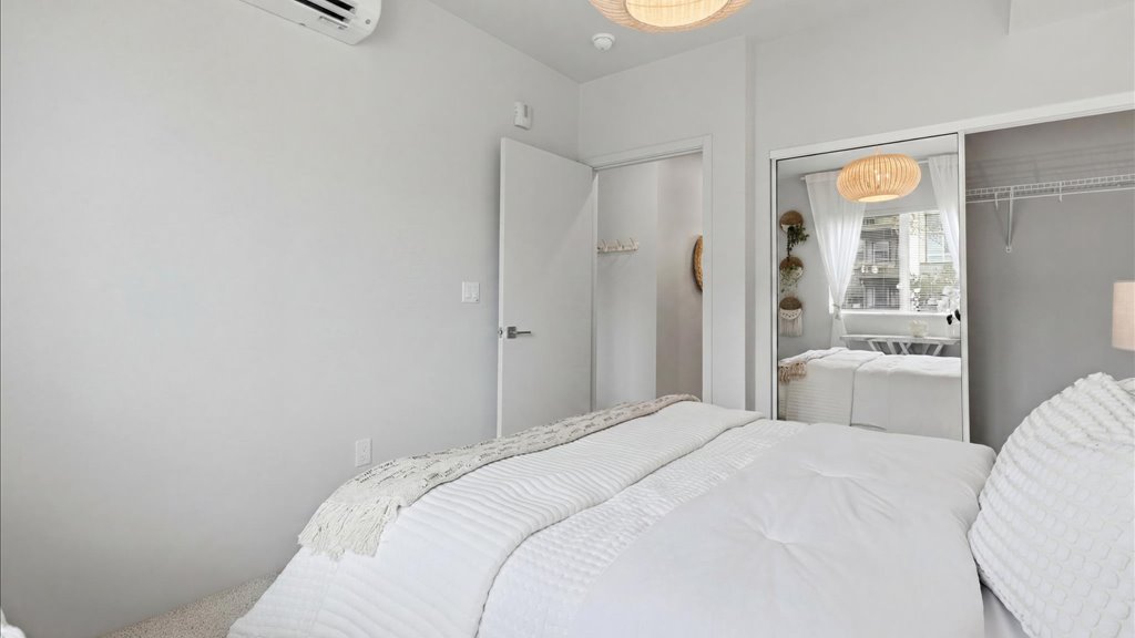Interior bedroom with sliding door closet open to bathroom