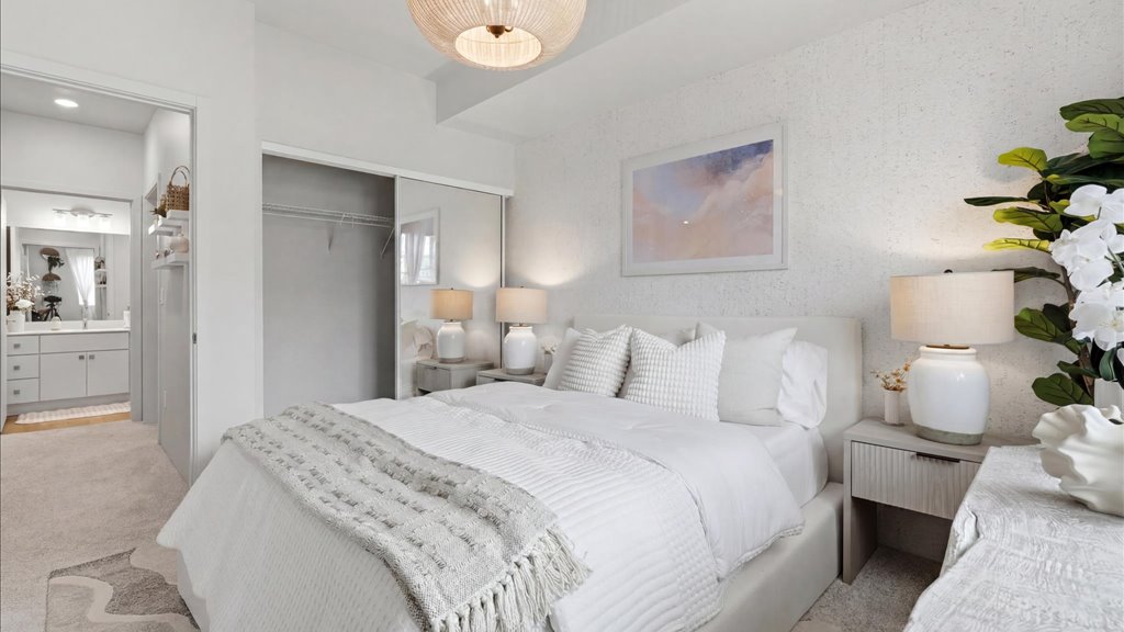 Interior bedroom with sliding door closet open to bathroom