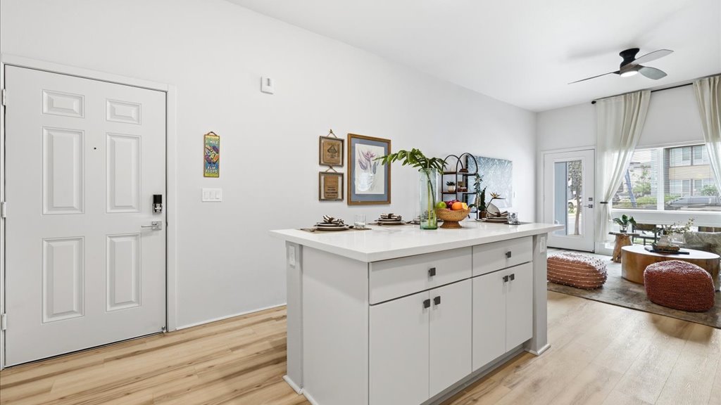 Interior kitchen with stainless steel appliances open to living room