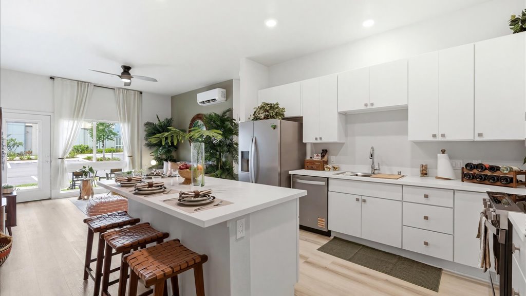 Interior kitchen with stainless steel appliances open to living room