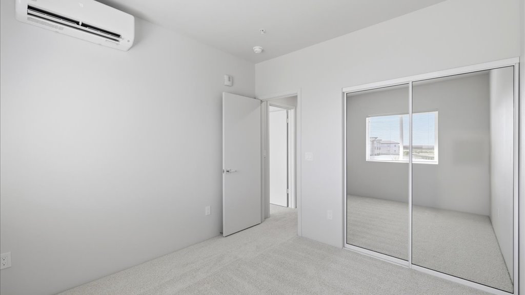 Interior bedroom with large window and sliding door closet